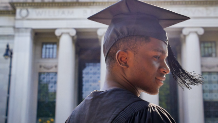 Side profile of a young person wearing a graduation hat and robes.