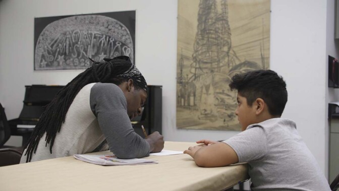 A young man gets instruction on art at the Watts Towers Arts Center | Still from "The Watts Towers Arts Center" ab s11