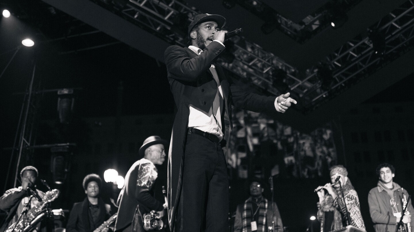 A black and white photograph of the Pan Afrikan Peoples Arkestra during a New Year's Eve 2019 performance. Mekala Sessions is in the foreground. | Samantha Lee ab s11