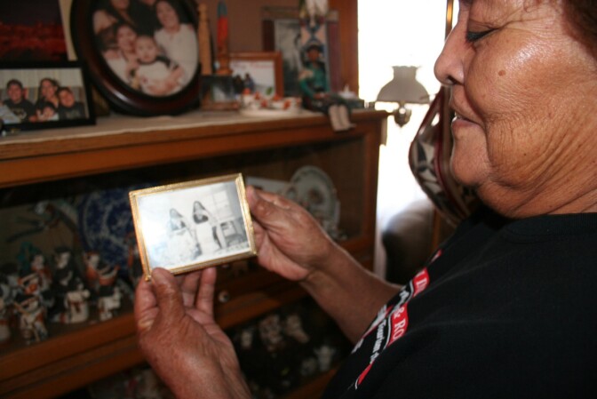 Pueblo of Acoma elder Mary Lowden holds a photo of her mother and her aunt, both pottery makers. As a girl, Mary and her sisters would walk down to the highway to sit at the general store and sell the pottery they helped make.