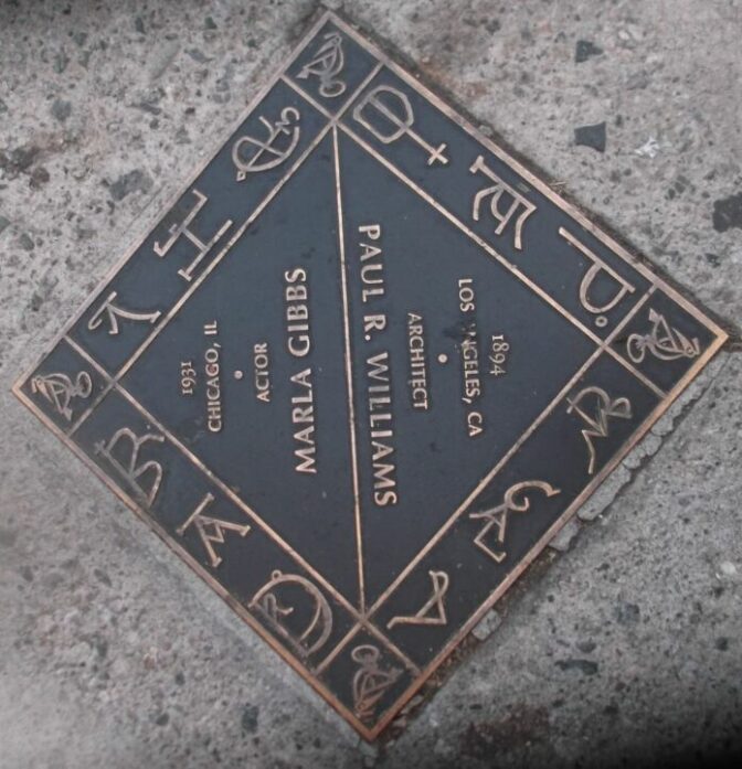 A plaque on the cement floor of the street with the names Marla Gibbs and Paul R. Williams in it.