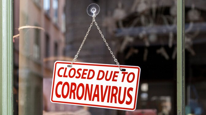 A sign at a business reads "Closed due to coronavirus." | iStock