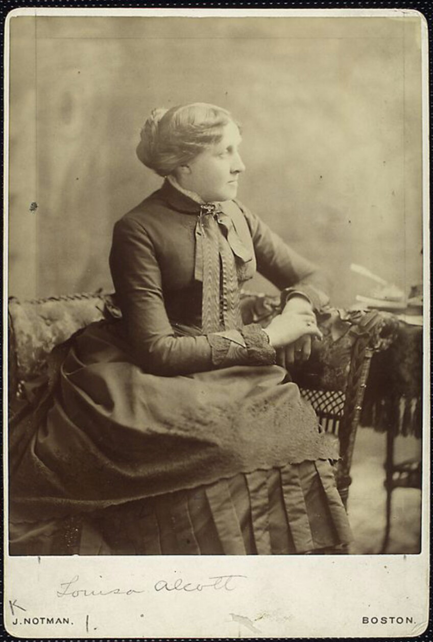 Black and white photo of a seated woman in turn of the century dress.