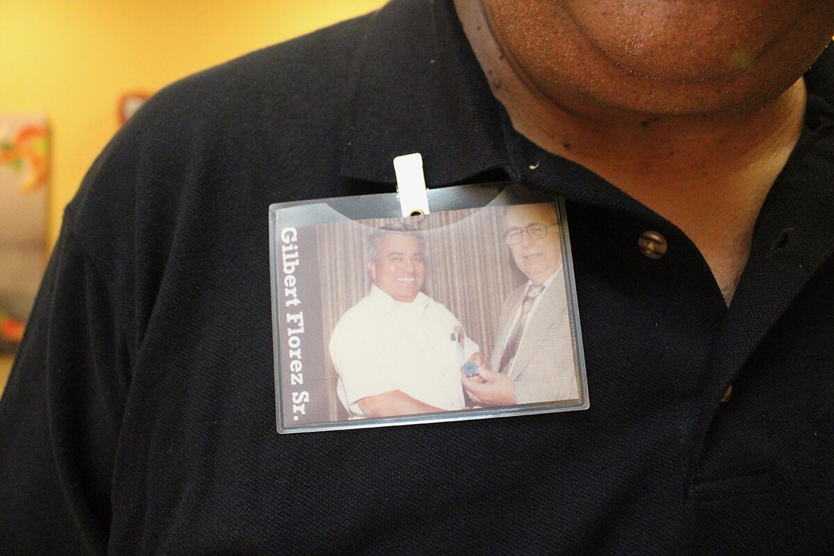 Gilbert BevenFlorez Jr. wears a badge with a photo of his father, Gilbert Florez Sr. | Jean Trinh