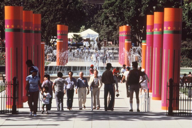 Visitors walk down a pathway of colorful pillars for the 1984 Olympic games.