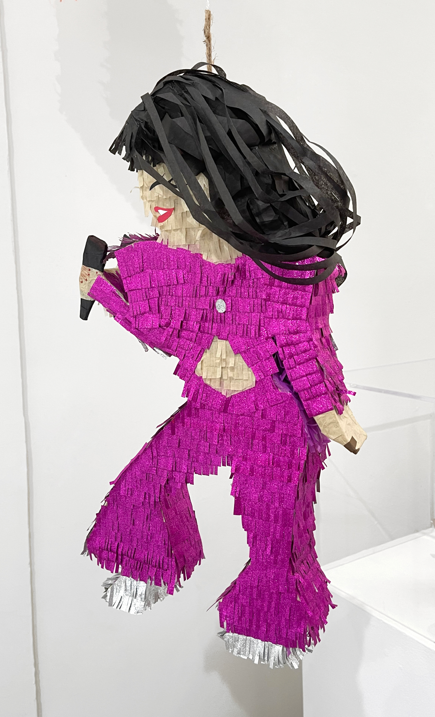 A singing girl in a hot pink suit and heels made out of crepe