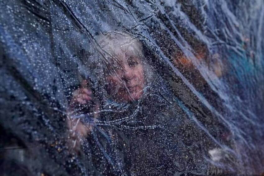 Rain drops are seen on outdoor protective plastic sheeting surrounding a woman at a cafe in Galway, Ireland, October 20, 2020. | REUTERS/Clodagh Kilcoyne