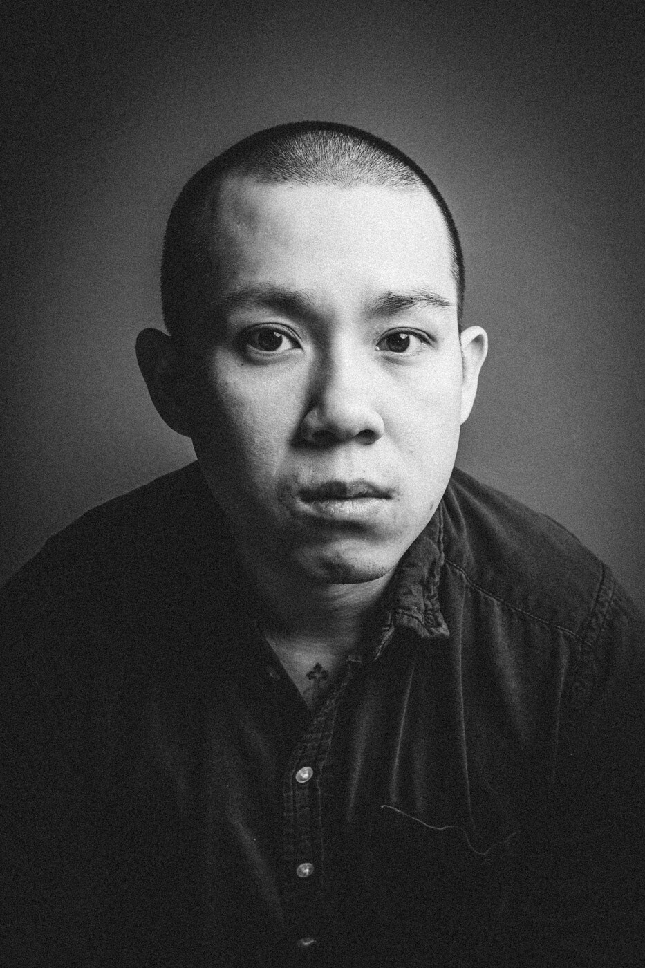 A black and white portrait Chef Jon Yao of Kato taken from the chest up. Yao is looking into the camera with moody lighting on his face.