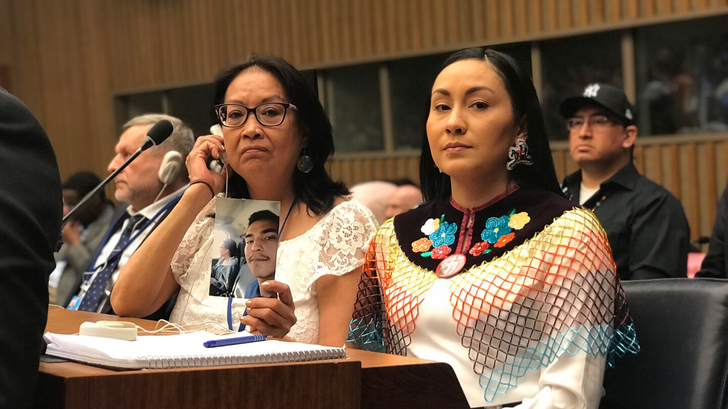 Member of Colten Boushie's family look stoicly into the camera, one of the holding up his picture. | From "We Will Stand Up"