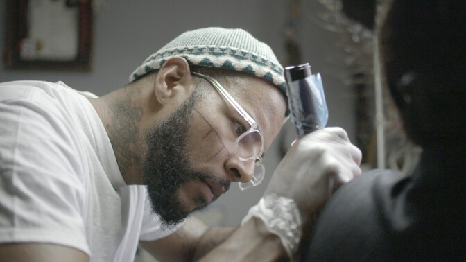 Isaac Weber is intensely focused on his tattoo work.