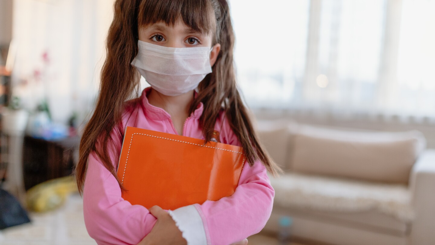 little girl wearing face mask at home
