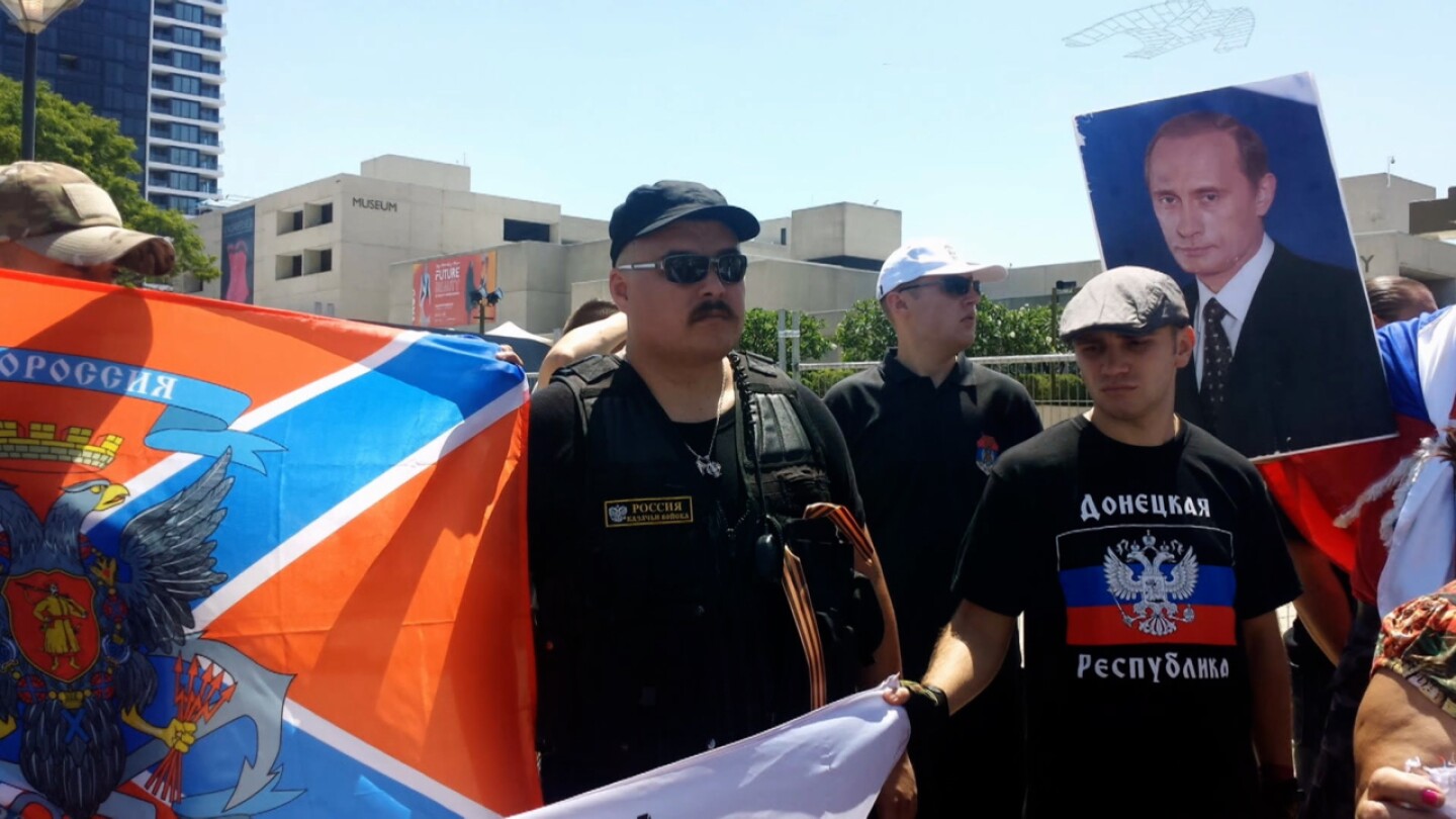 Putin supporters gather to hold up flags and signs.