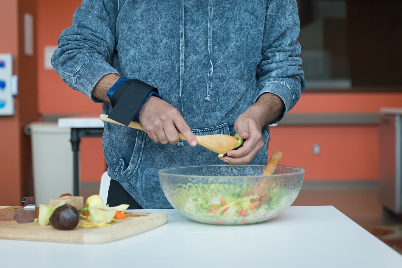 Perez’s hands trembled as he tried to cut vegetables, so a weighted band was wrapped around his wrist to help keep him steady.