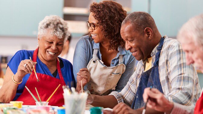 A group of adults make art together. | iStock