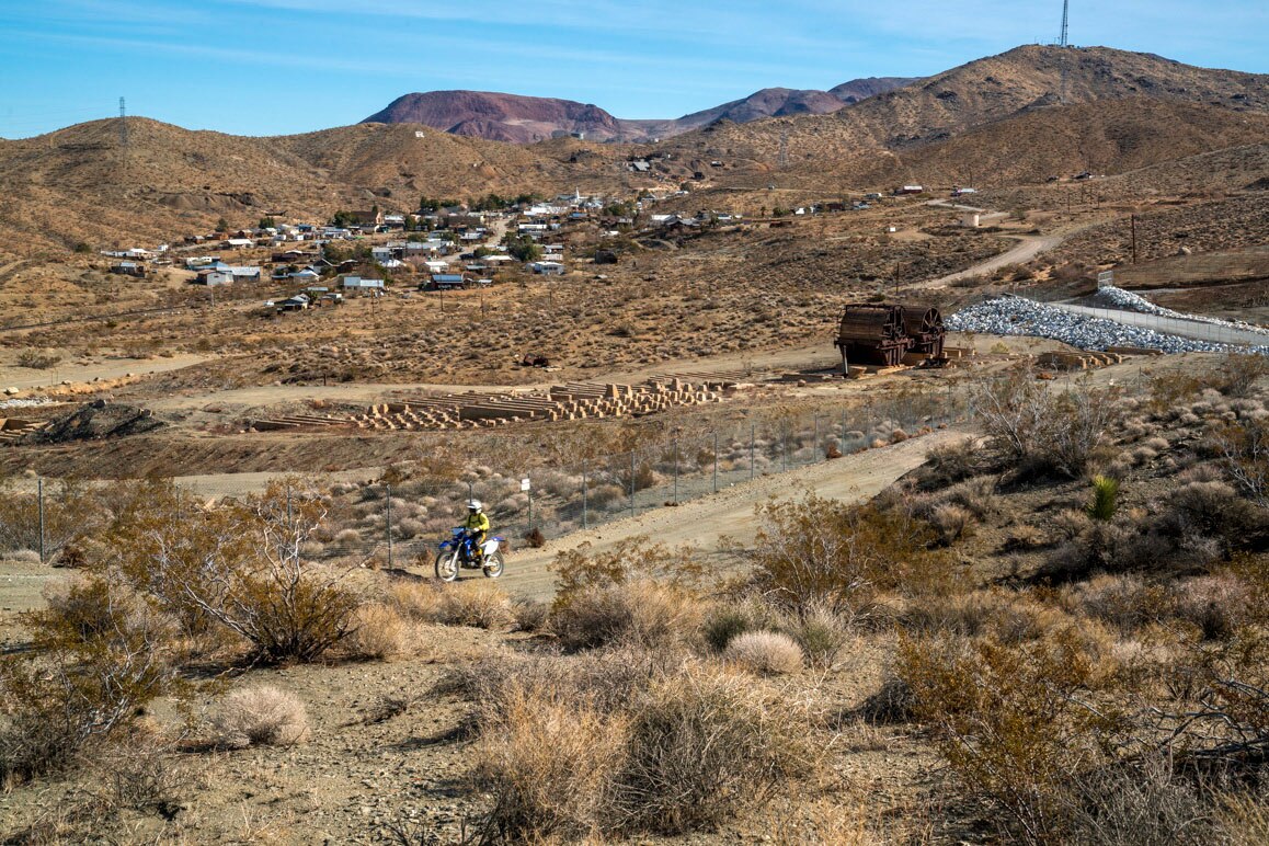 A solo dirt bike rider motors by Randsburg’s defunct mill site that is considered by federal authorities to be highly contaminated with arsenic from historic mining activity in the area. | Kim Stringfellow.