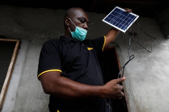 An employee of Salpha Energy unboxes a solar panel for home installation in Sagbo-Kodji community, amid concerns over the spread of coronavirus disease (COVID-19) in Lagos, Nigeria April 25, 2020. | REUTERS/Temilade Adelaja