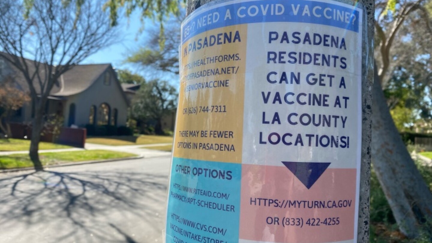 A sign on a lamppost in a residential area advertises how and where Pasadena residents can get vaccinated.