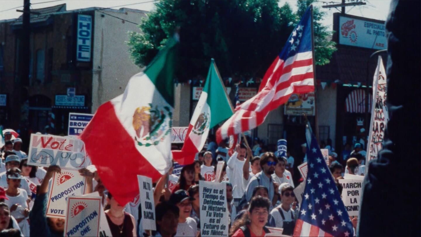 Rally against Prop 187 with American and Mexican flags waving | Still from "187"