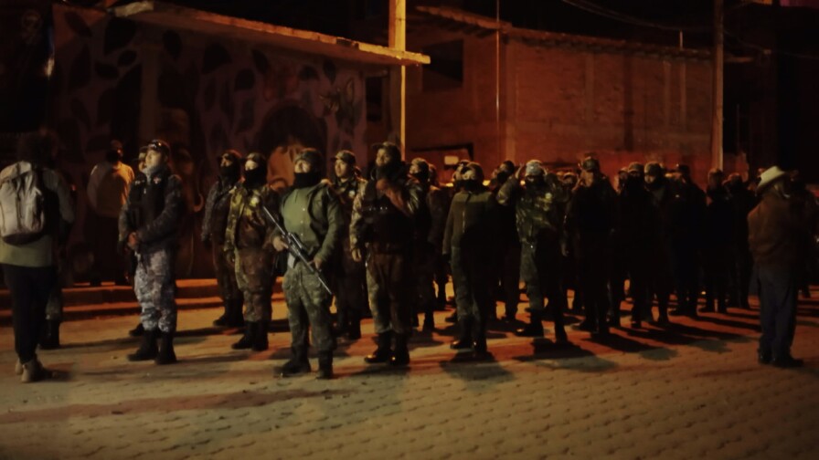 Armed soldiers gather in lines.