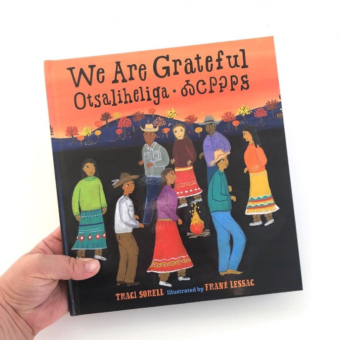 Book cover of “We Are Grateful: Otsaliheliga” by Traci Sorell and illustrated by Frané Lessac featuring colorful illustrations of people. Thanksgiving book list