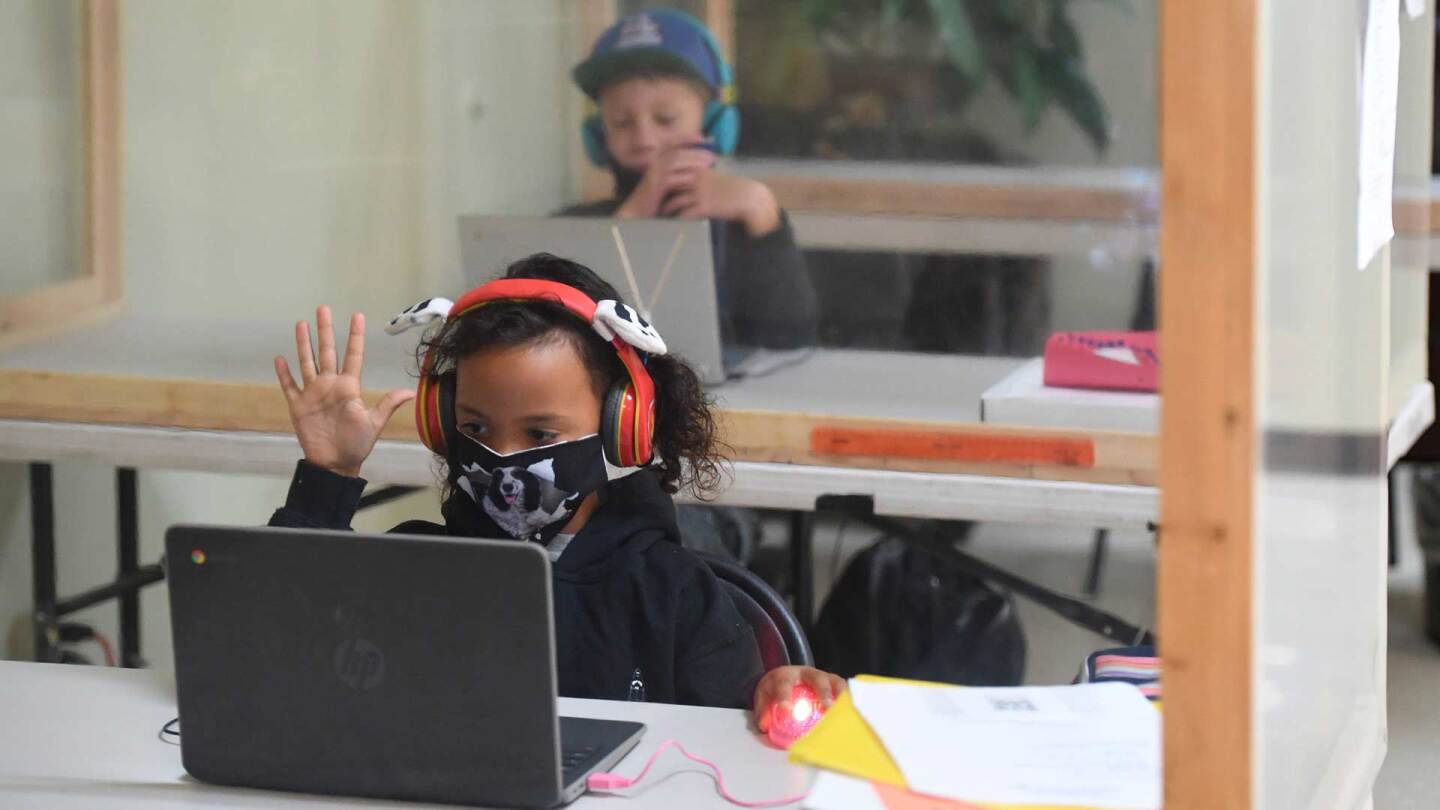 Students follow along remotely with their regular school teacher's online live lesson from separated by plastic barriers at STAR Eco Station Tutoring & Enrichment Center on September 10, 2020 in Culver City, California