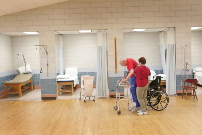 Shirley Gooding, a physical therapist, helps William Rexroat exercise at the Quincy Veterans Home in Illinois, Feb. 17, 2005. | Scott Olson/Getty Images
