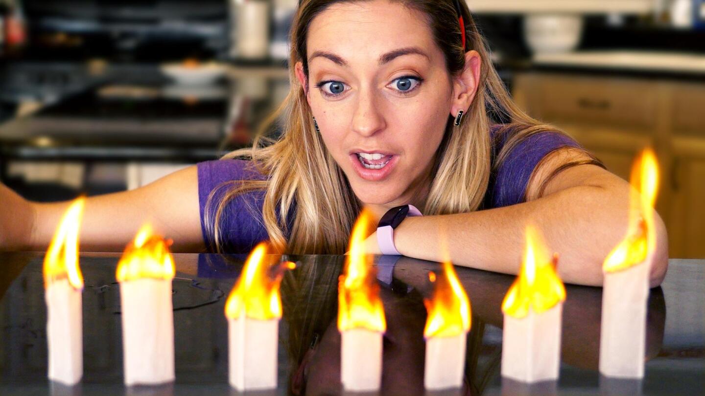 "Physics Girl" host Dianna Cowern marvels at the flames burning in from of her.