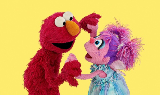 A red and pink Muppet play together