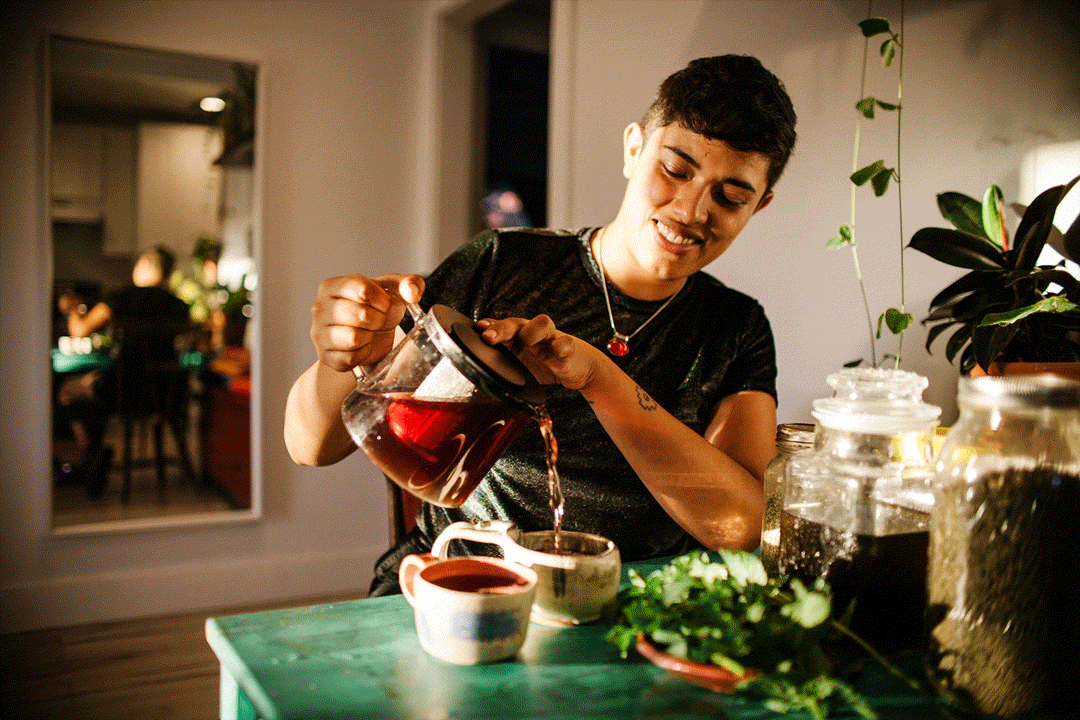 Loba pours nourishing tea for anemia which includes nettles, alfalfa, hibiscus flowers, and mint from the garden. | Samanta Helou Hernandez