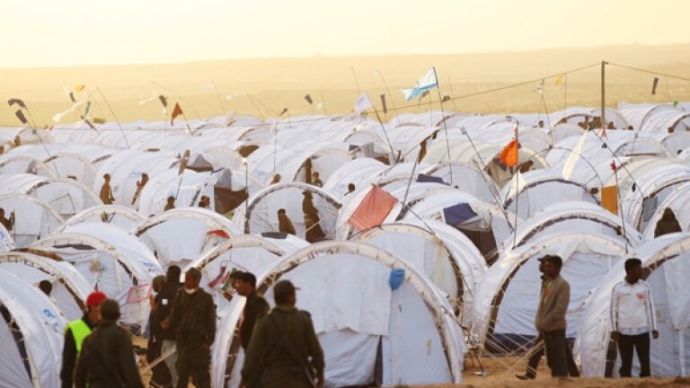 Bangladeshi migrant workers who recently crossed into Tunisia from Libya walk in a United Nations displacement camp | Getty Images