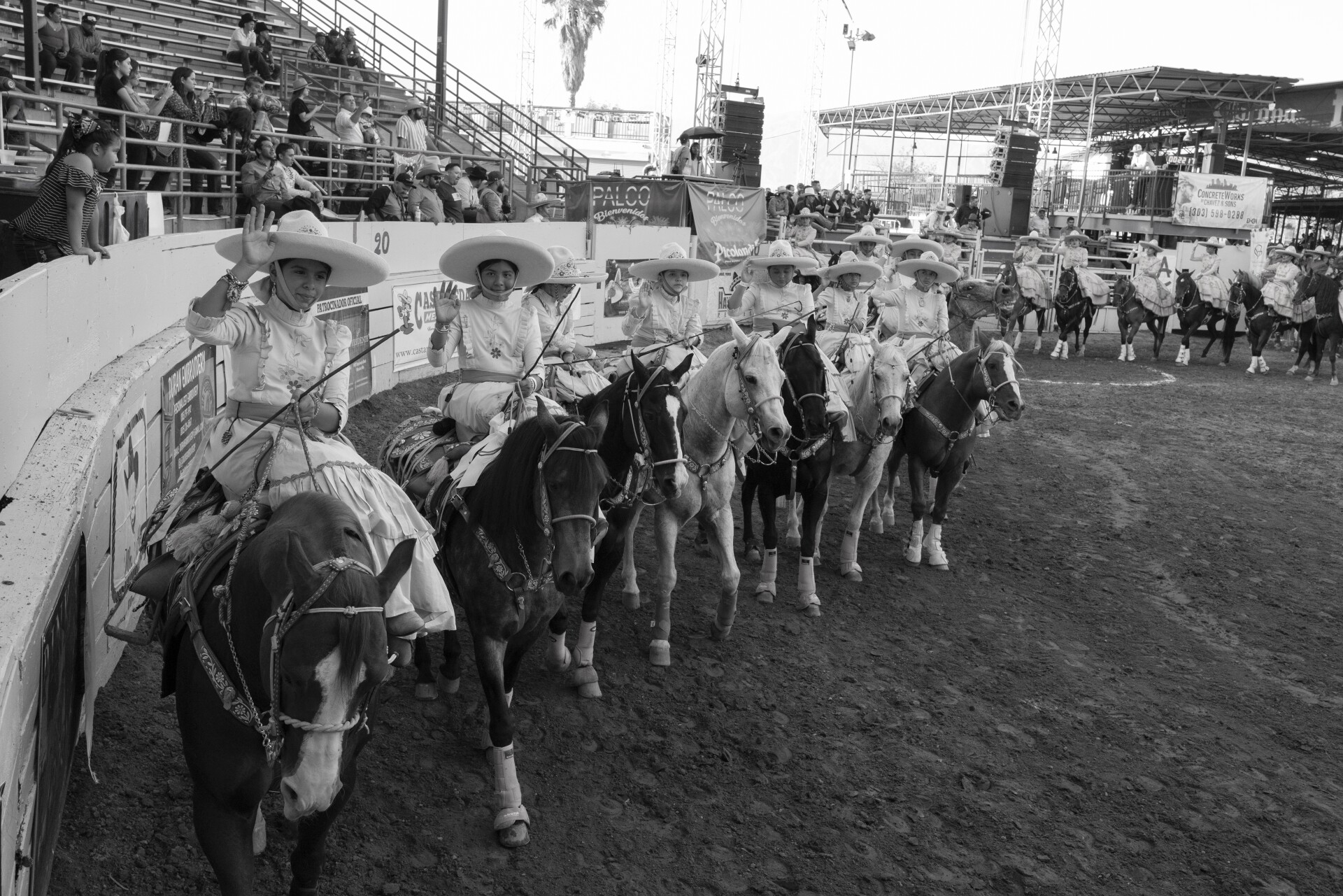 Mujeres jóvenes montando el sillín lateral mientras caminan alrededor de un corral redondo.