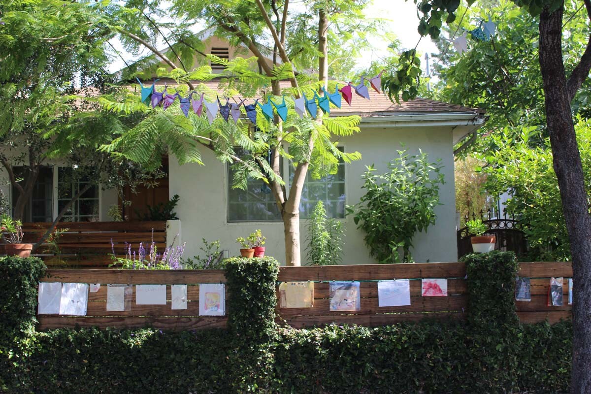 Dan Fields’ Los Feliz fence gallery features children's artwork hanging from a cable.