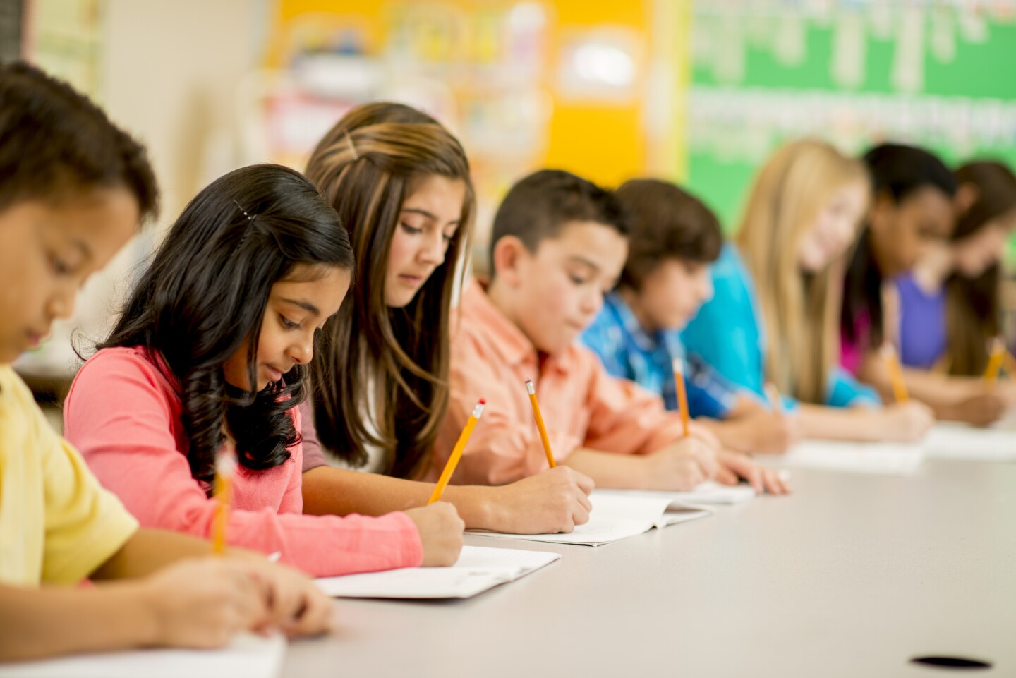A row of students taking a test. | iStock
