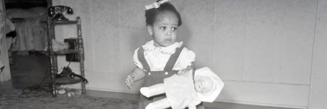 A little African American girl holding a doll | California State University Northridge