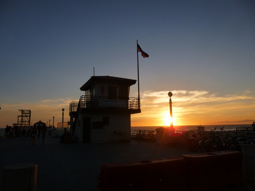 A lifeguard station at Manhattan Beach Pier during sunset.