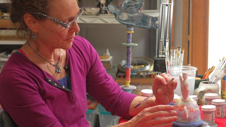 Ceramic artist Susan Garson paints a menorah