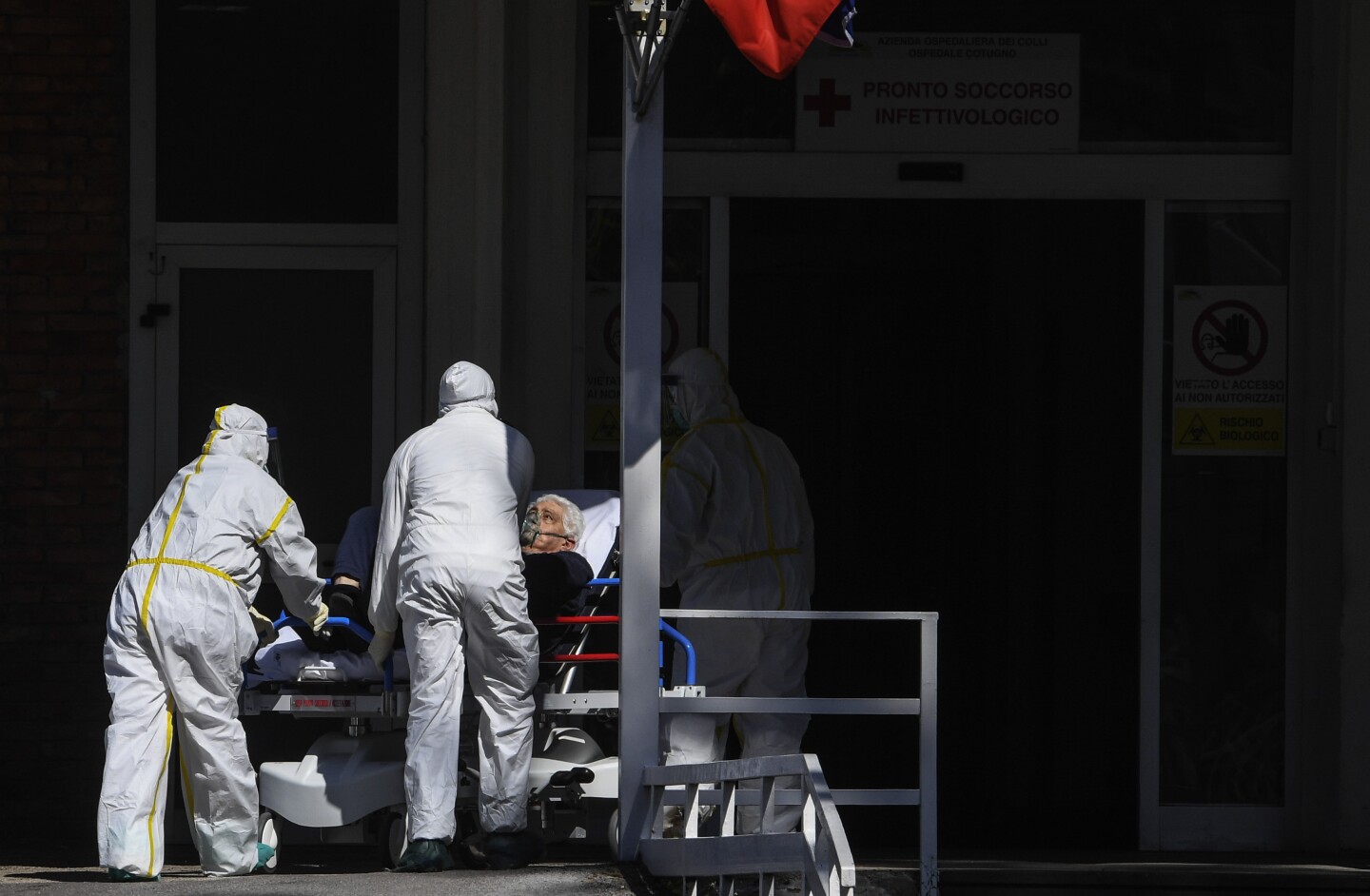 Paramedicals carry a Coronavirus COVID-19 patient with a stretcher, to take him to the hospital ward where he will be treated.