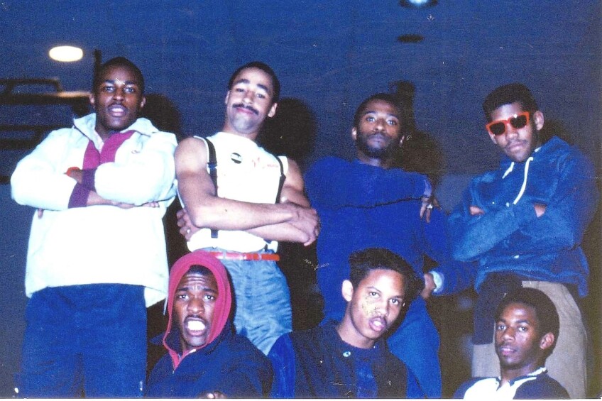 A group of young African American men wearing sunglasses and sporting looks from the 1980s.