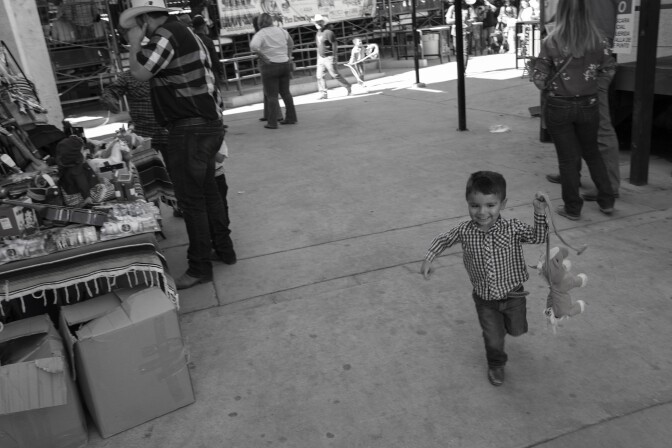 Un niño corre con un caballo de juguete en Pico Riviera.