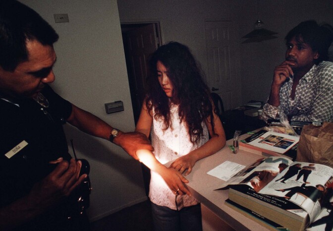As her boyfriend looks on, a Japanese sex worker assaulted in her apartment shows Officer Dona her wounds. | Joseph Rodriguez