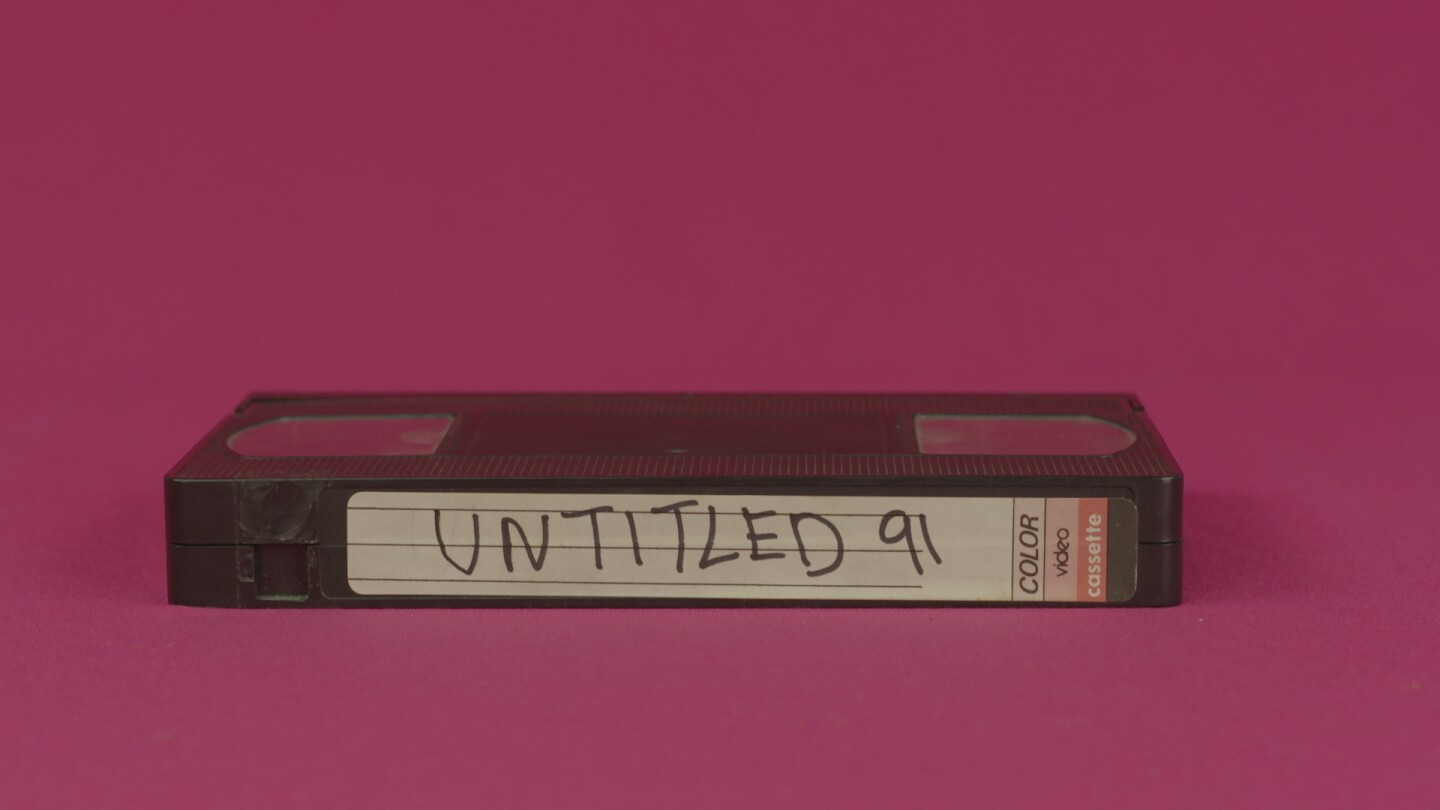 Hector Gachan music video still: a VHS tape on a fuschia background. Tape reads "Untitled 91," which is the name of the song.