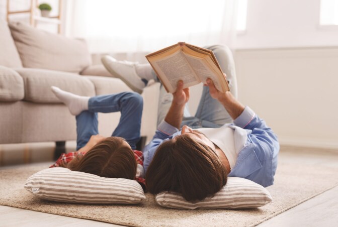 A man and a little boy read together.