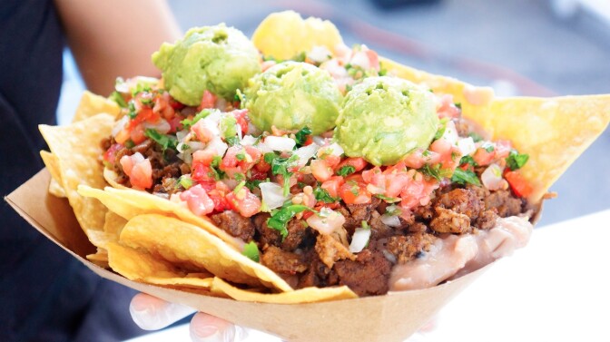 Cena Vegan's nacho boat comprises chips topped with your choice of plant-based proteins plus: refried beans, pico de gallo, cashe chipotle crema | Courtesy of Cena Vegan