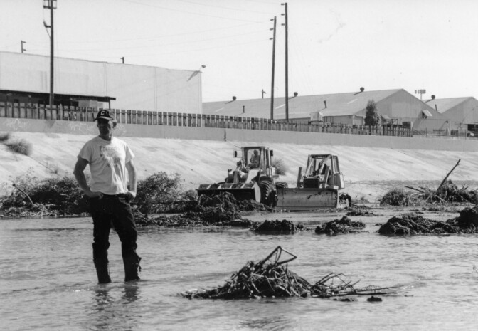 Lewis MacAdams, founder of Friends of the Los Angeles River, stands in the river as bulldozers clear vegetation from its channel in anticipation of heavy El Nino-driven rains, expected in the winter of 1997-98 | Blake Gumprecht, courtesy of FoLAR