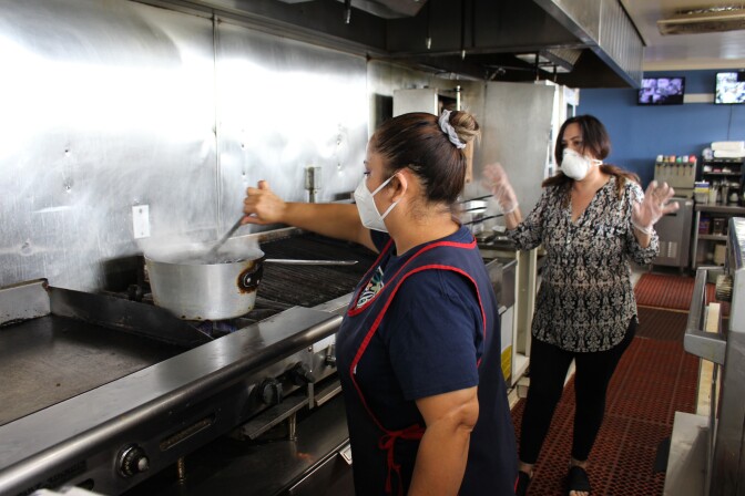 Janet, an employee at Aliki's Greek Taverna, stirs food for Fueling the Fearless