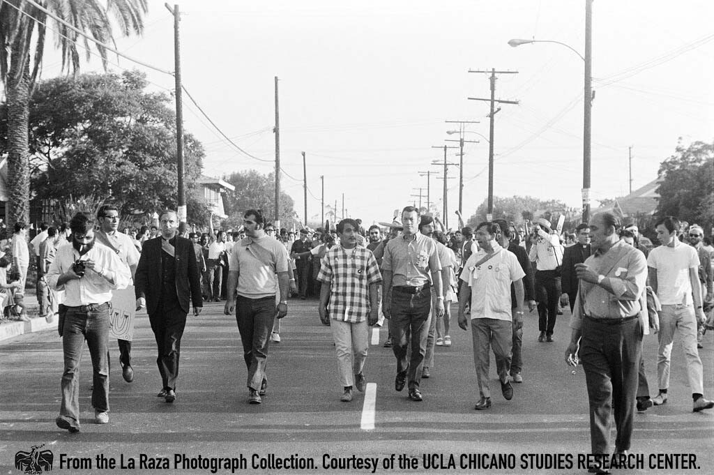 CSRC_LaRaza_B4F3C1_Staff_016 Father Luce and others lead protesters during the National Chicano Moratorium in Laguna Park | La Raza photograph collection. Courtesy of UCLA Chicano Studies Research Center