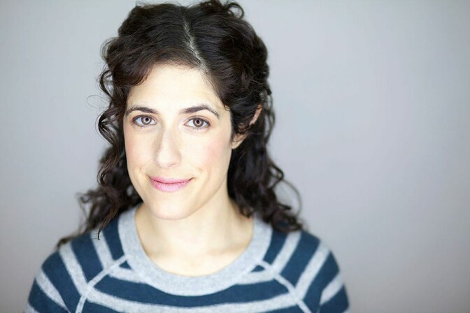 A woman with brown curly hair.
