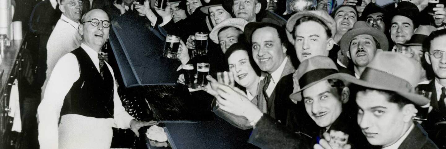 Men and women raising their glasses at a bar | Los Angeles Examiner Photographs Collection, University of Southern California Libraries