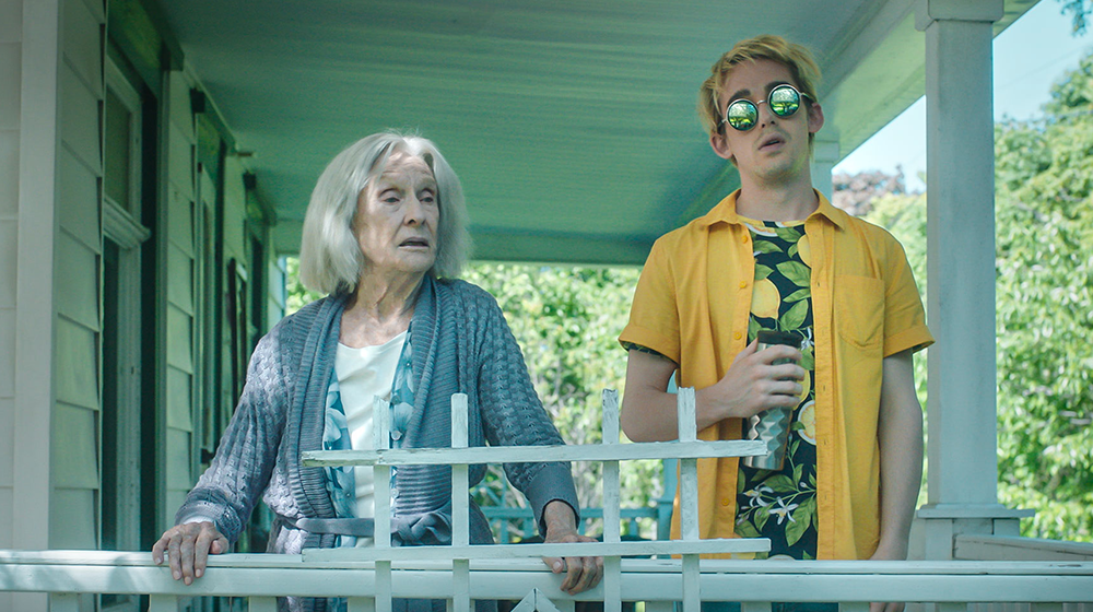 An older woman and a person wearing a yellow polo shirt and sunglasses.