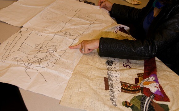Denise Sheridan points out the details of an in-progress quilt portraying Nobel Peace Prize winner Ralph Bunche. | Chris Daly